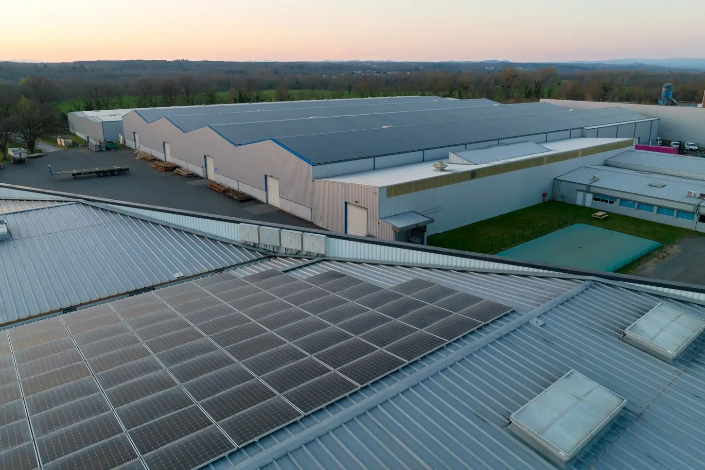 Solárne panely nainštalované na streche priemyselnej budovy, znázorňujúce strešnú fotovoltiku pre komerčné využitie